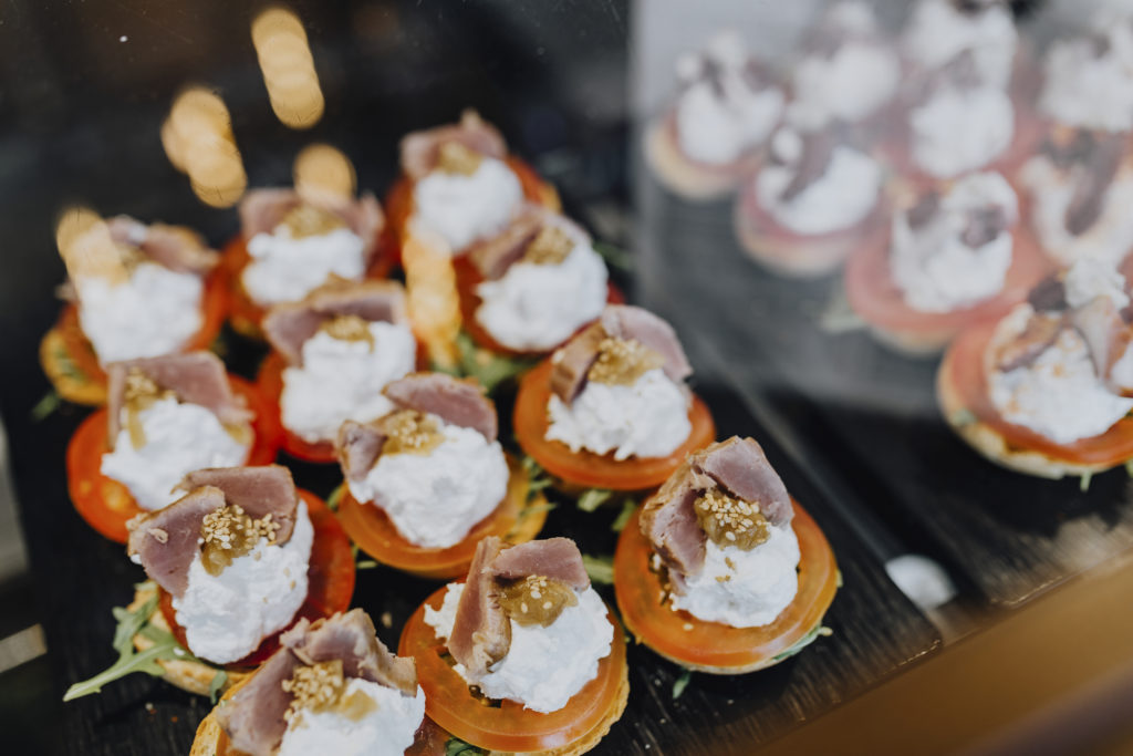 overhead photo of hors d'oeuvres lined up on a wooden board