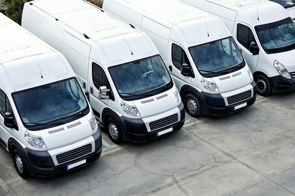 aerial photo of a fleet of white delivery vans