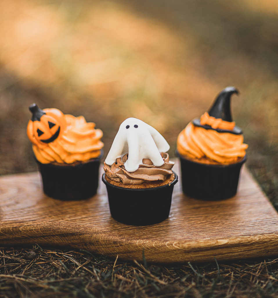 color photo of three halloween cupcakes on a wooden cutting board
