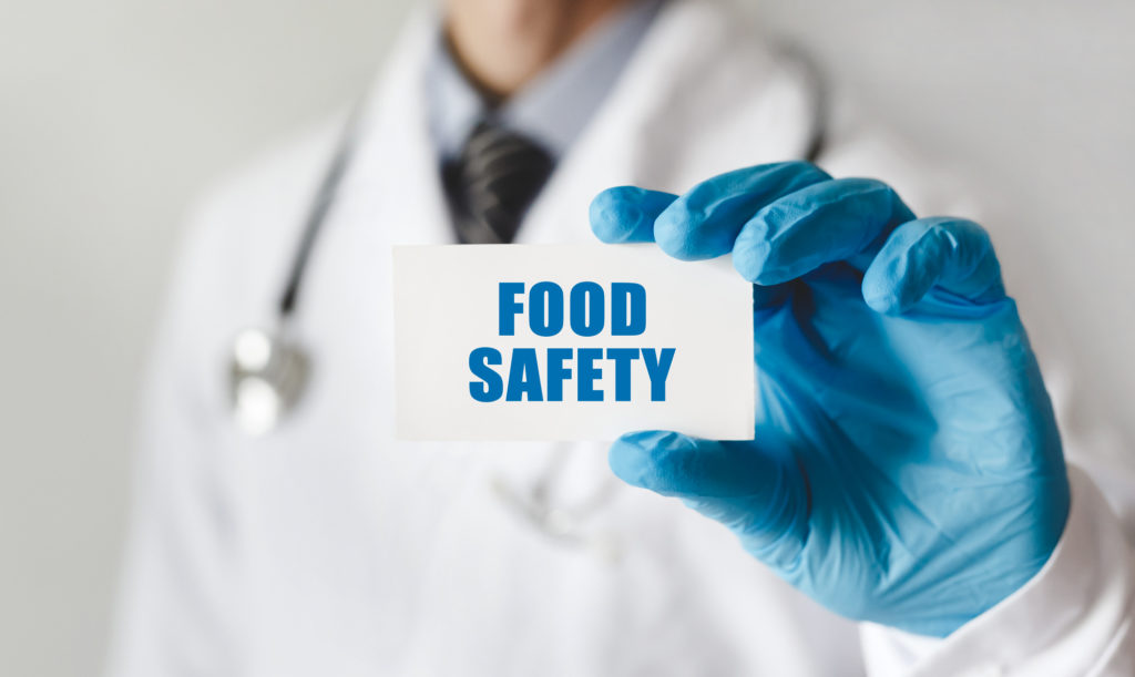 photo of a doctor holding a card with text Food Safety