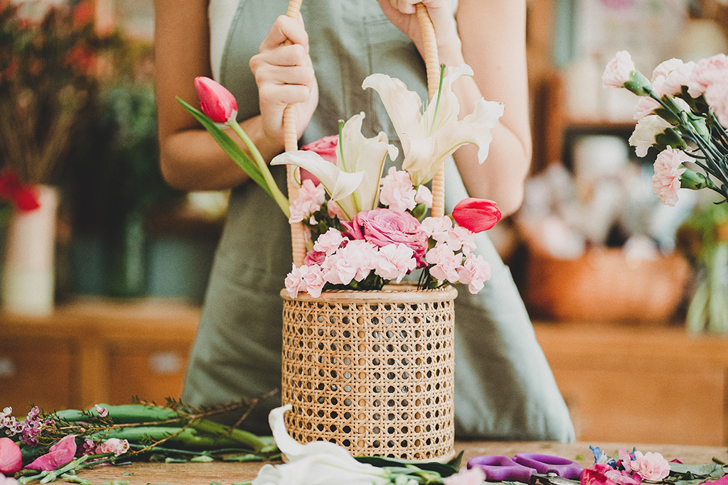 florist holding a floral arrangement of lilies and tulips