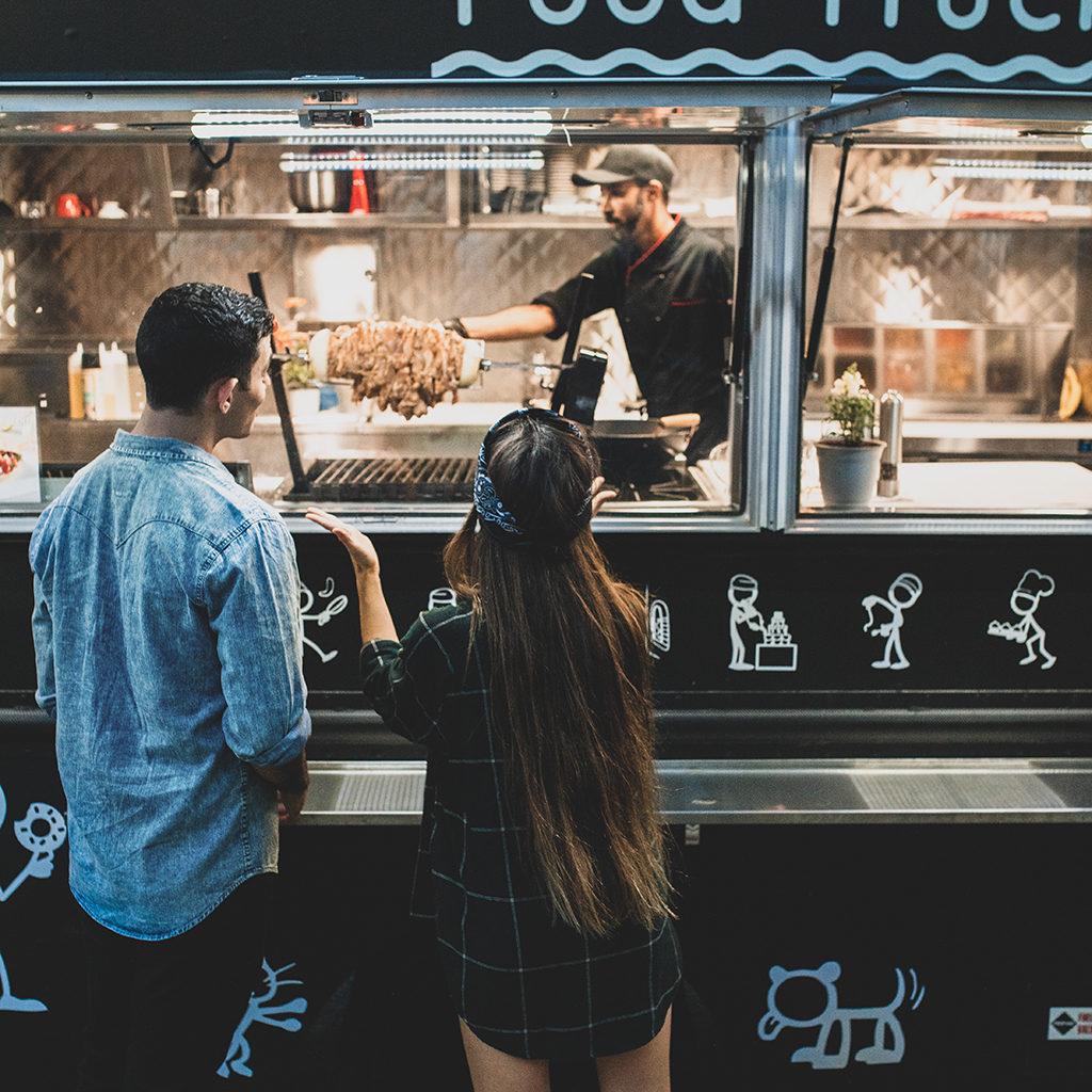 man and woman buying food from a food truck