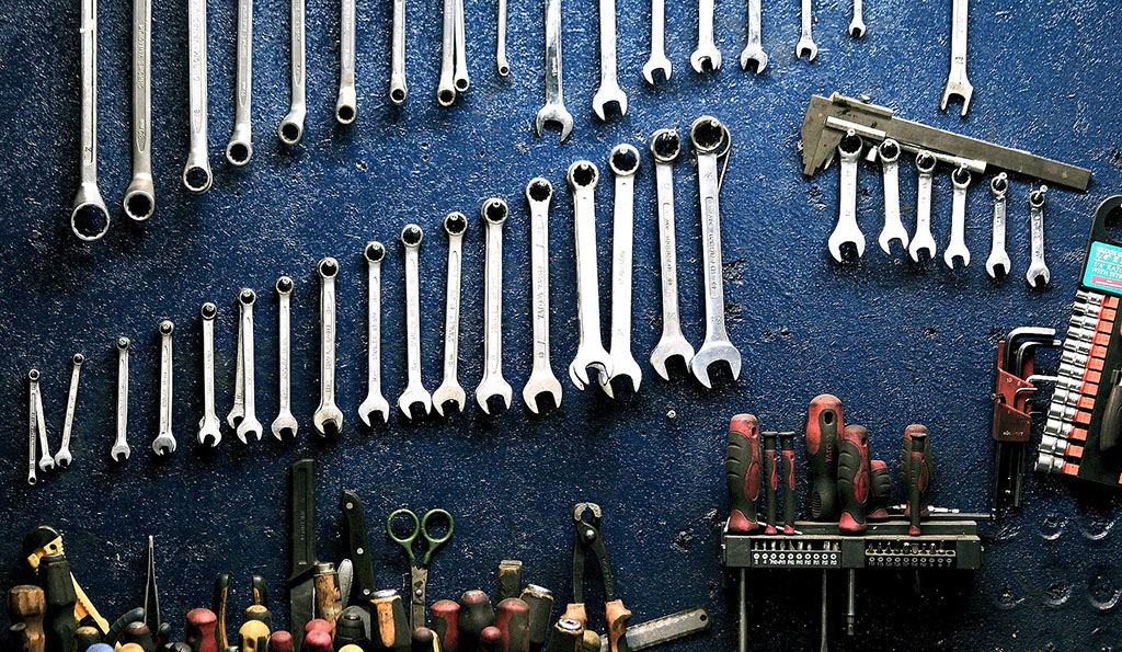 wrenches and other tools hanging on a work bench