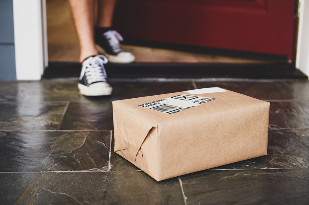 person collecting delivery package from front porch